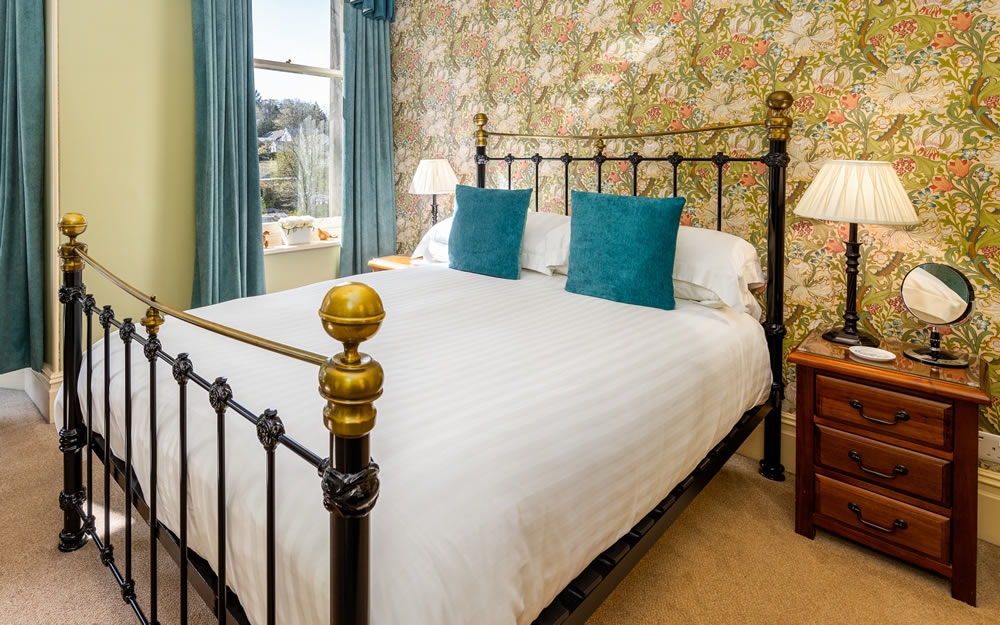 Room 2, flexible family room with cast iron double bed and teal curtains