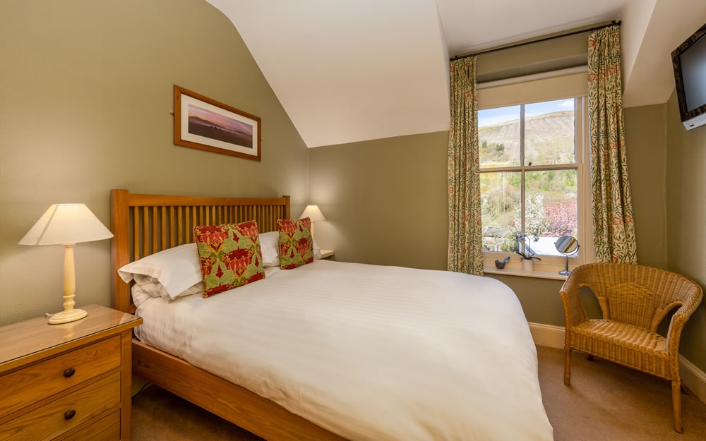 Room 3, cosy double room under the eaves with rosebud curtains and wicker chair
